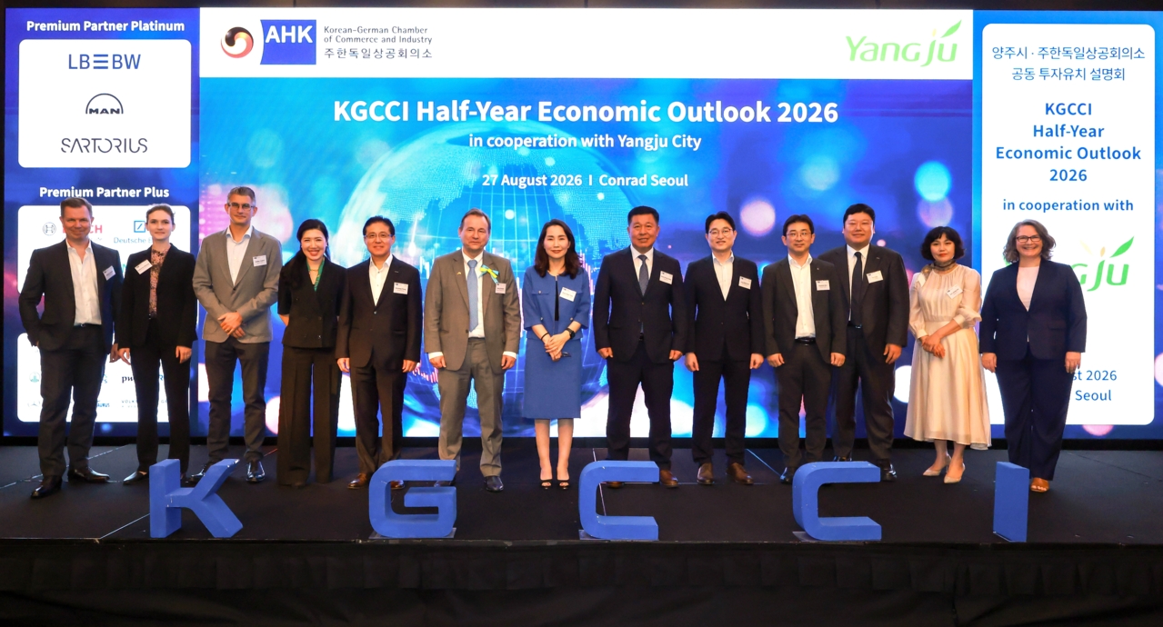 Speakers on stage at the KGCCI Half-Year Economic Outlook 2026, standing behind the letters K G C C I, with the PremiumPartner ranks printed on the backdrop