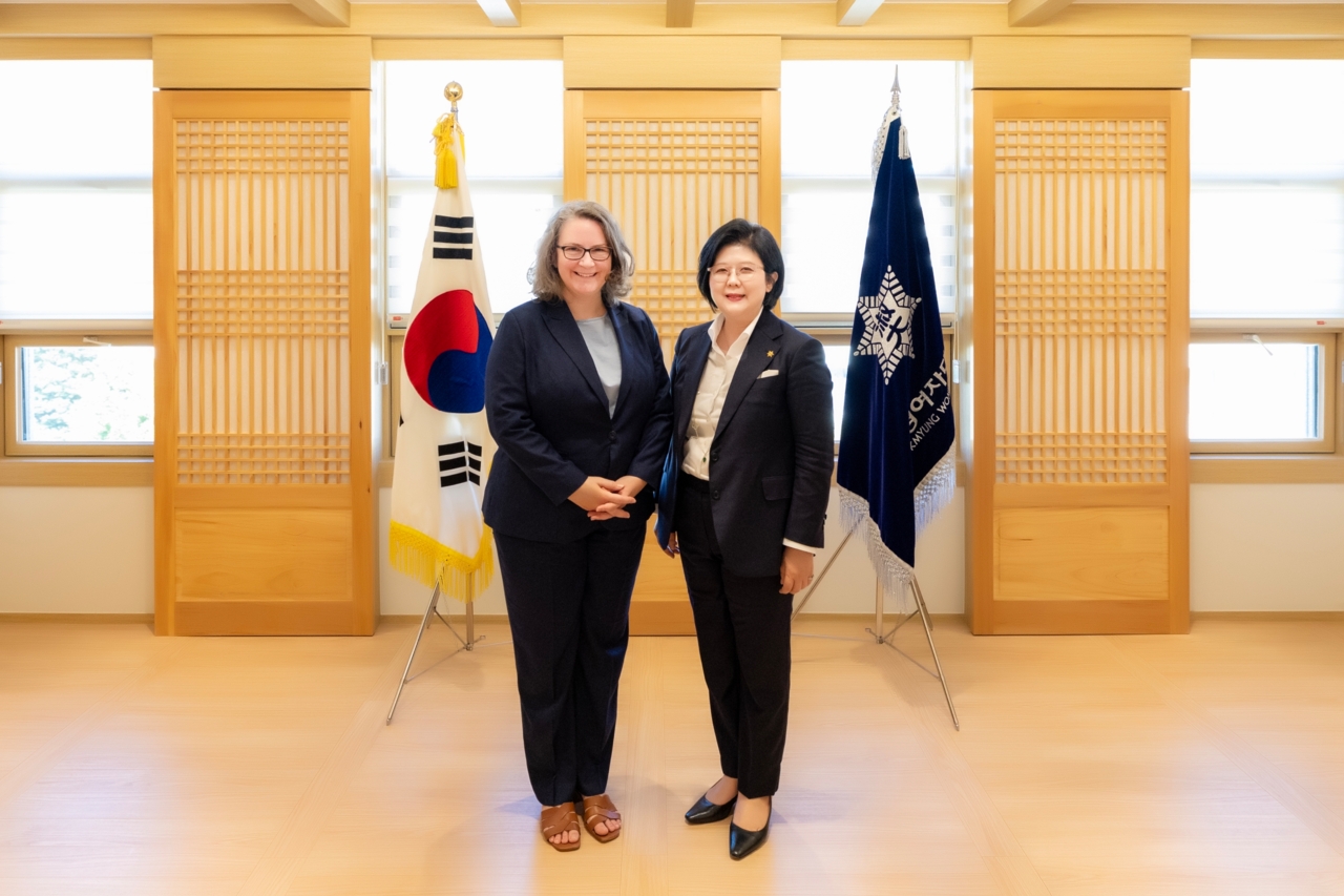 The President and CEO of KGCCI with the President of Sookmyung Women’s University, between the flag of the Republic of Korea and the university standard